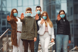 ludzie noszący maski ochronne pokazujący znak stop